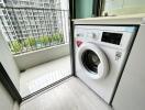 Laundry area with washing machine and outside view