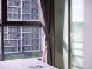 Bedroom with large window and view of other buildings