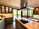 Modern kitchen with wooden countertops, glass cabinets, and seating area