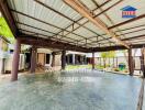 Covered outdoor area with concrete flooring and garden space.