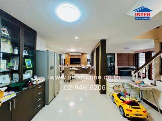 Spacious living area with kitchen and dining space, featuring modern furniture and children