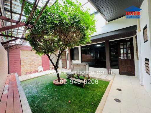 Outdoor patio area with greenery and seating