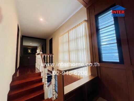 Hallway with wooden stairs and windows