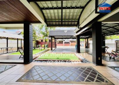 Spacious outdoor patio area with covered seating and play area