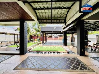 Spacious outdoor patio area with covered seating and play area