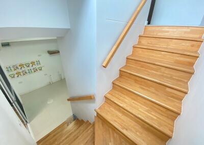 Wooden staircase leading down to a bright room