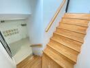 Wooden staircase leading down to a bright room