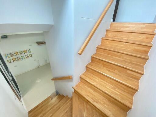 Wooden staircase leading down to a bright room