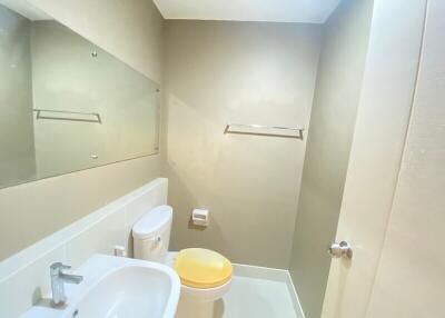 Modern bathroom with sink, toilet, and large mirror