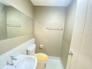 Modern bathroom with sink, toilet, and large mirror