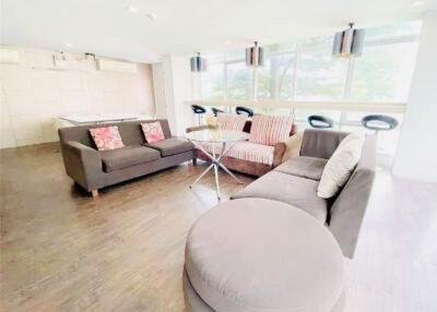 Spacious living room with modern furnishings and bar stools