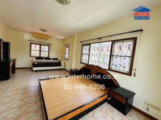 Spacious bedroom with bed frame, sofa, and windows