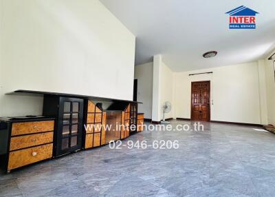 Spacious living room with tiled flooring and wooden cabinets