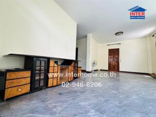 Spacious living room with tiled flooring and wooden cabinets