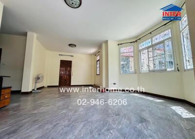 Spacious living room with large windows and tiled floor