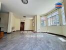 Spacious living room with large windows and tiled floor