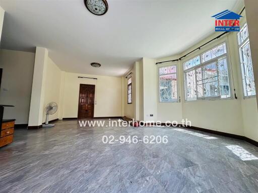 Spacious living room with large windows and tiled floor