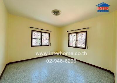 Spacious bedroom with tiled floor, large windows, and ample natural light