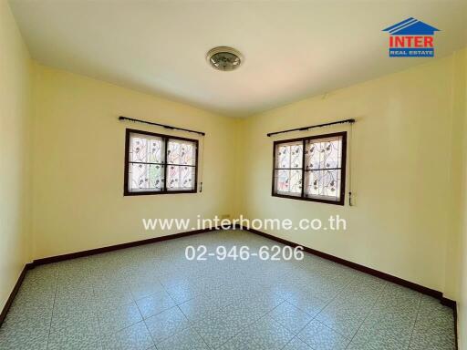 Spacious bedroom with tiled floor, large windows, and ample natural light