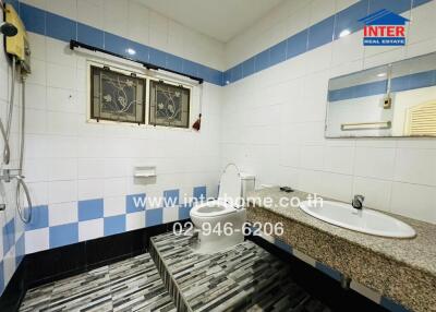 Modern bathroom with tiled walls, shower, toilet, and sink