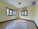 Photo of a living room with windows, tiled floor, and air conditioning unit