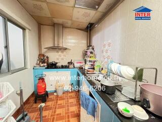 A compact kitchen with blue cabinets, various kitchen appliances, and pantry items.