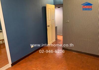 Bedroom with blue walls and wooden floor