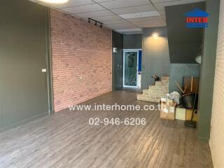 Spacious living area with brick wall and staircase