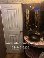 Small bathroom with mirror, sink, and tiled walls