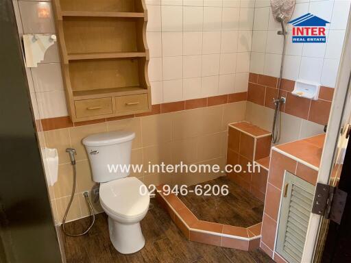 Bathroom with toilet, shower, and shelving