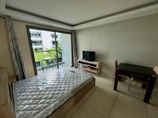 Bedroom with bed, table, chairs, TV, and a balcony