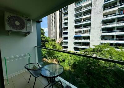 Balcony with a small table and two chairs, overlooking neighboring buildings