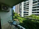 Balcony with a small table and two chairs, overlooking neighboring buildings