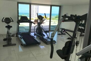 Modern gym room with exercise equipment and sea view