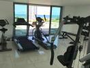 Modern gym room with exercise equipment and sea view