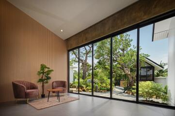 Modern living room with large glass windows and garden view