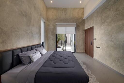 Modern bedroom with a large bed and a view of an outdoor space