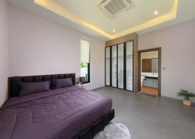 Spacious modern bedroom with a bed, wardrobe, and en suite bathroom