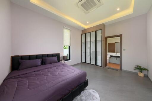 Spacious modern bedroom with a bed, wardrobe, and en suite bathroom