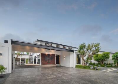 Modern exterior of a house with large driveway and lush landscaping