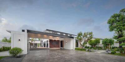 Modern exterior of a house with large driveway and lush landscaping