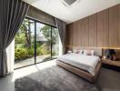 Spacious bedroom with large glass doors and garden view