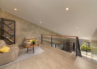 Modern loft living area with comfortable seating and bookshelf