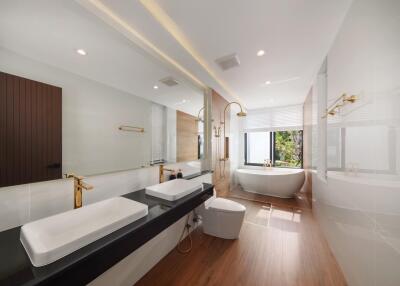 Modern bathroom with large bathtub, double sinks, and wooden accents