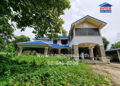 Front view of a large house with blue roof