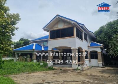 Two-story house with blue roof and white exterior