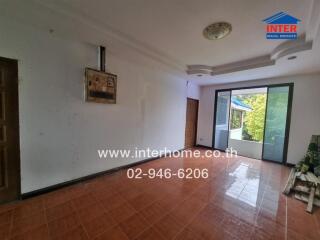 Spacious living room with large windows and tiled floor