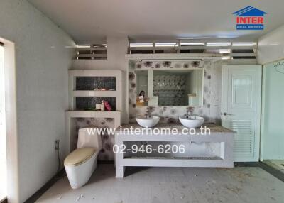 Spacious bathroom with twin sinks and a separate toilet area