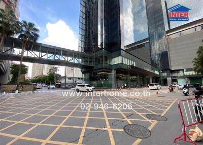 Main building exterior with glass facade and parking area