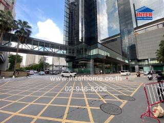 Main building exterior with glass facade and parking area